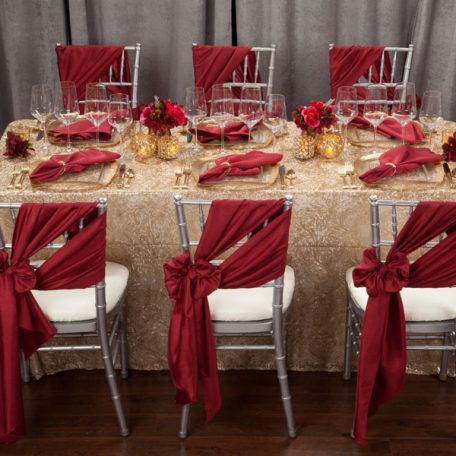 Golden Helena Beaded overlay shown over an ivory Shantung Table Linen. Topped off with our Ice Square with Gold Rim Charger and a Merlot Shantung Napkin