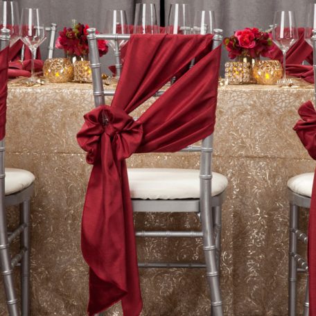 Golden Helena Beaded overlay shown over an ivory Shantung Table Linen. Topped off with our Ice Square with Gold Rim Charger and a Merlot Shantung Napkin