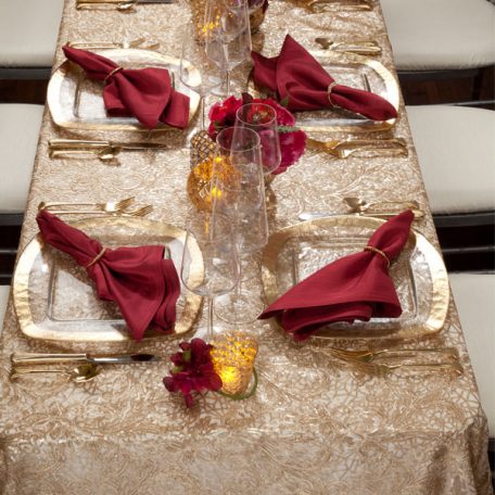 Golden Helena Beaded overlay shown over an ivory Shantung Table Linen. Topped off with our Ice Square with Gold Rim Charger and a Merlot Shantung Napkin