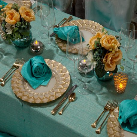 Ivory Rhythm Table Linen with on Gables Table Runner and a Lagoon Shantung napkin on an Ivory Florence Glass Charger