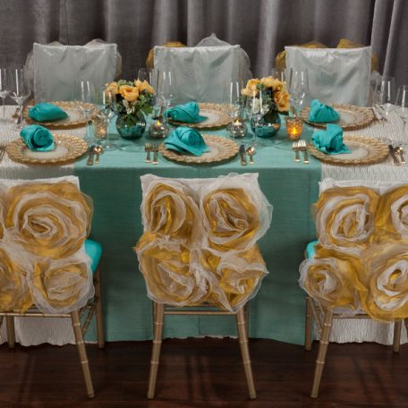 Ivory Rhythm Table Linen with on Gables Table Runner and a Lagoon Shantung napkin on an Ivory Florence Glass Charger