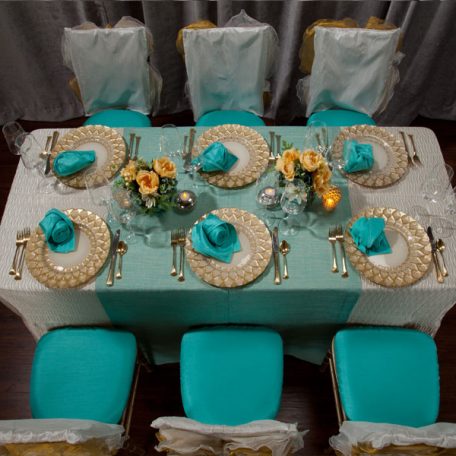 Ivory Rhythm Table Linen with on Gables Table Runner and a Lagoon Shantung napkin on an Ivory Florence Glass Charger