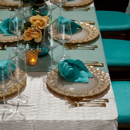 Ivory Rhythm Table Linen with on Gables Table Runner and a Lagoon Shantung napkin on an Ivory Florence Glass Charger